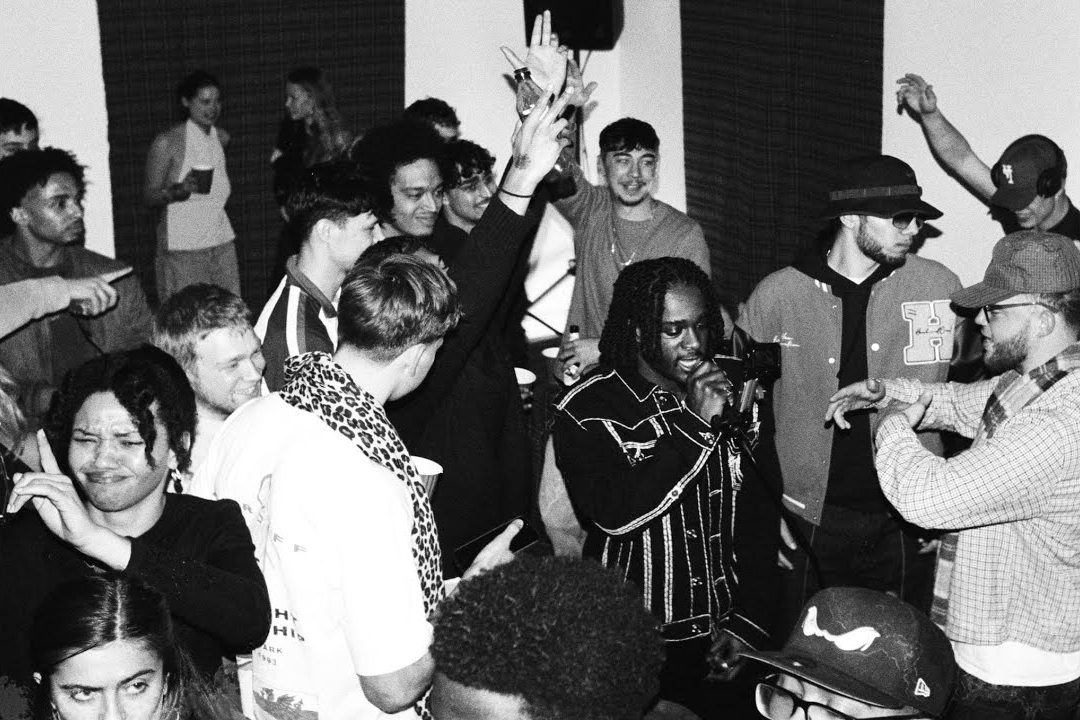 Black and white photo of the crowd and an MC at the Carbon Virtues cypher